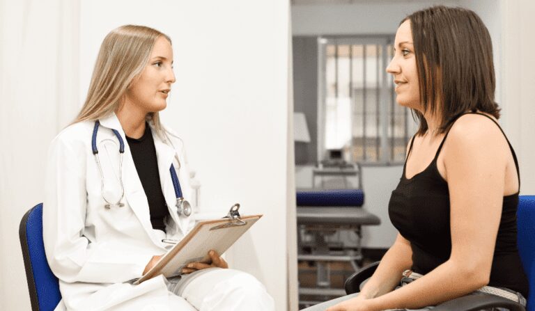 A woman discussing her varicose vein symptoms with a vein specialist.