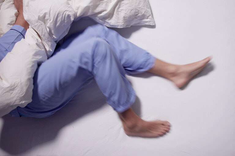 person suffering from restless legs at night in bed due to venous insufficiency