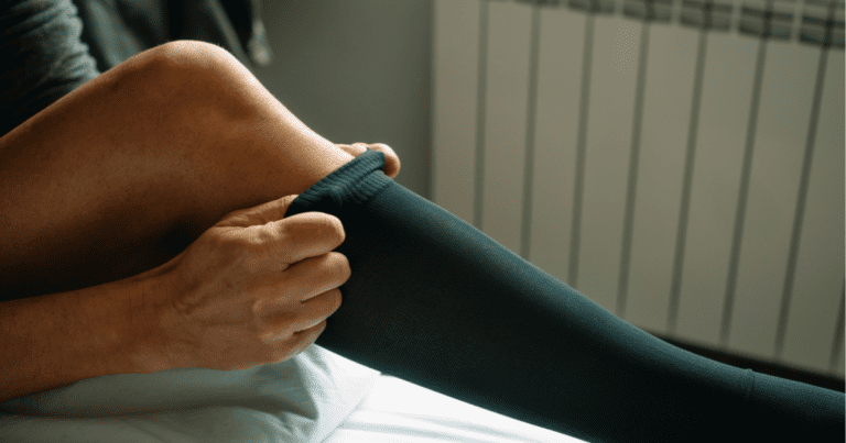 Person putting on a compression stocking, demonstrating a common treatment and management method for varicose veins.