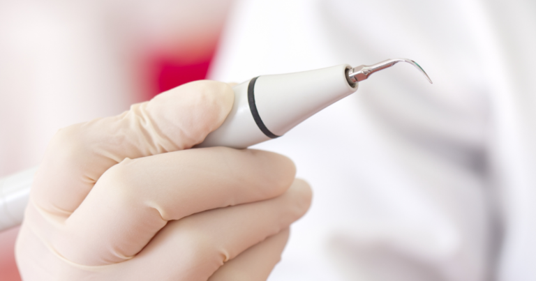 A gloved hand holds a medical instrument, representing tools used in vein treatments like sclerotherapy procedures.