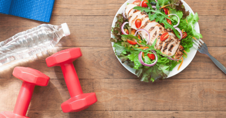 Weights, a glass of water, and a healthy salad, representing everyday habits that help prevent vascular disease and protect arteries.
