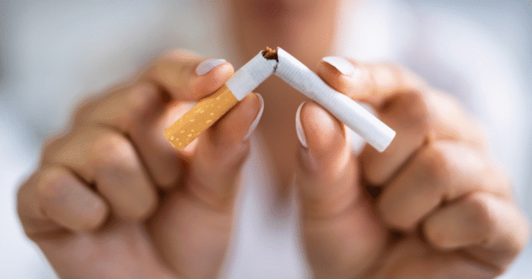 A person breaking a cigarette in half to stop smoking and reduce their vascular risk