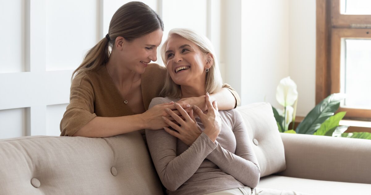 An older woman and younger female hugging and smiling because they understand vein health