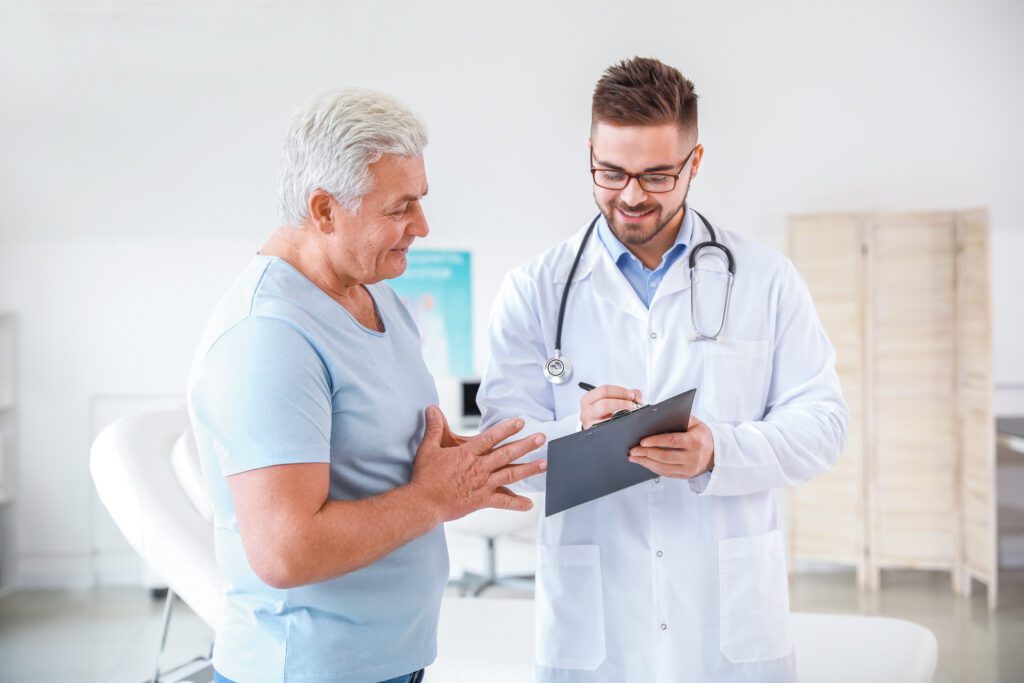 White-haired male discussing vein treatment options with a vein doctor