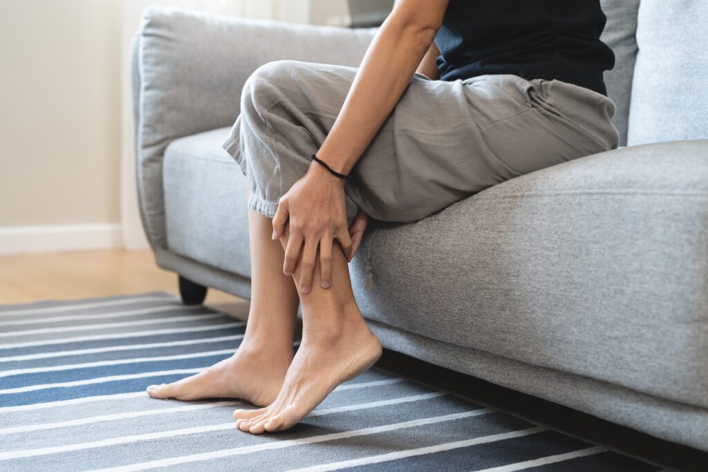 woman grasping her lower leg in pain