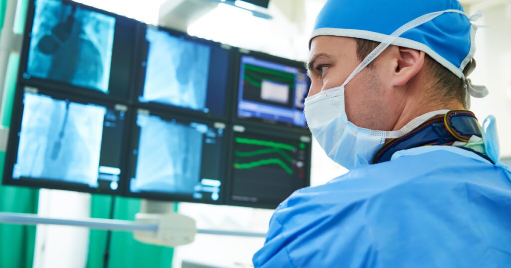 Vascular specialist examining X rays and MRI scans, illustrating diagnosis and treatment of peripheral artery disease with angioplasty.