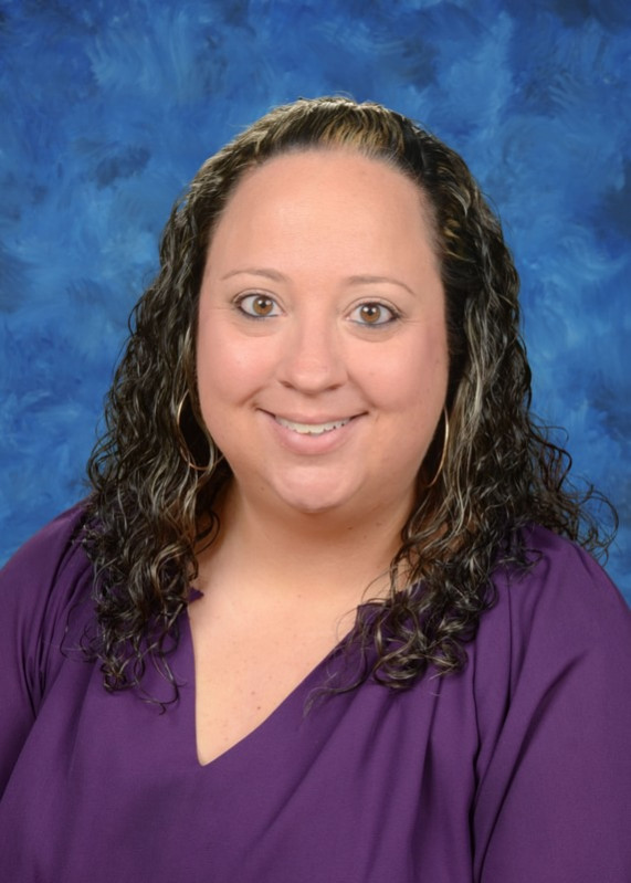 Professional portrait of a smiling educator against a blue background.