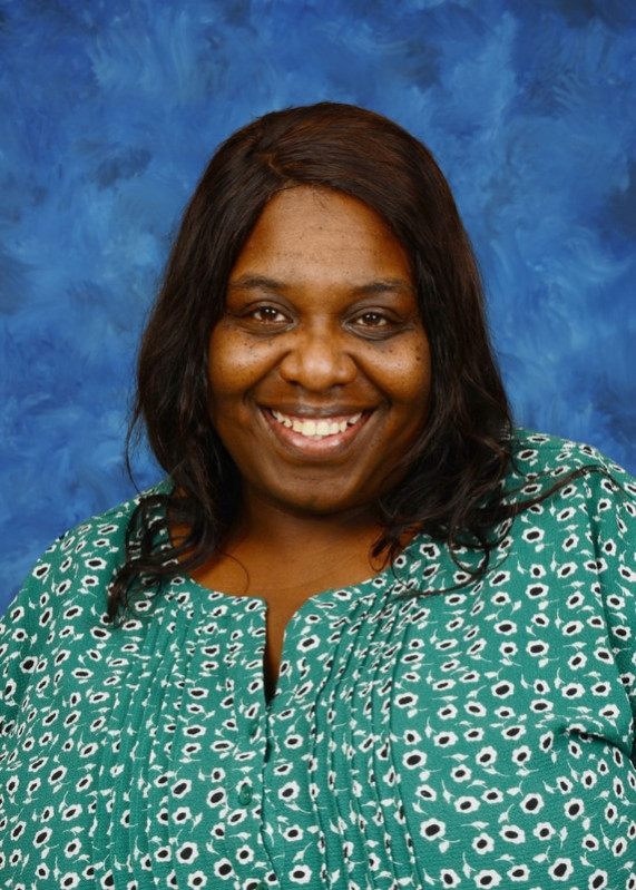 Professional portrait of a smiling educator against a blue background.