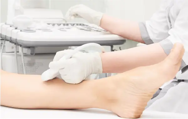 A vein specialist performing a vein ultrasound on a woman's leg