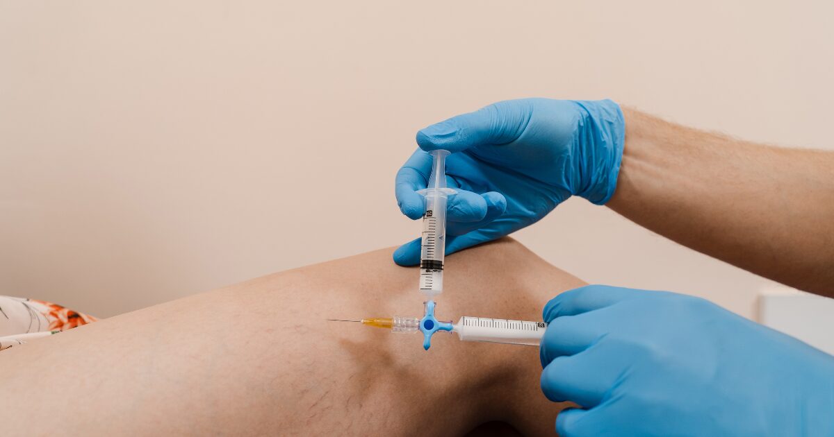 Vein specialist performing vein treatment on patient leg
