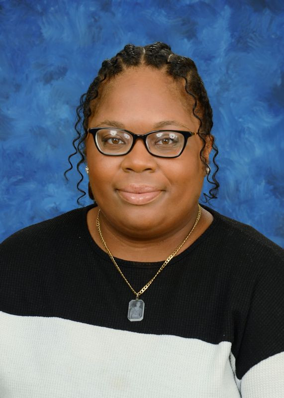 Portrait of Brenham ISD educator Keianna Wade-Smith smiling against a blue background.