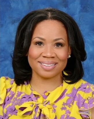 Portrait of Brenham ISD educator Konstance Lester smiling against a blue background.