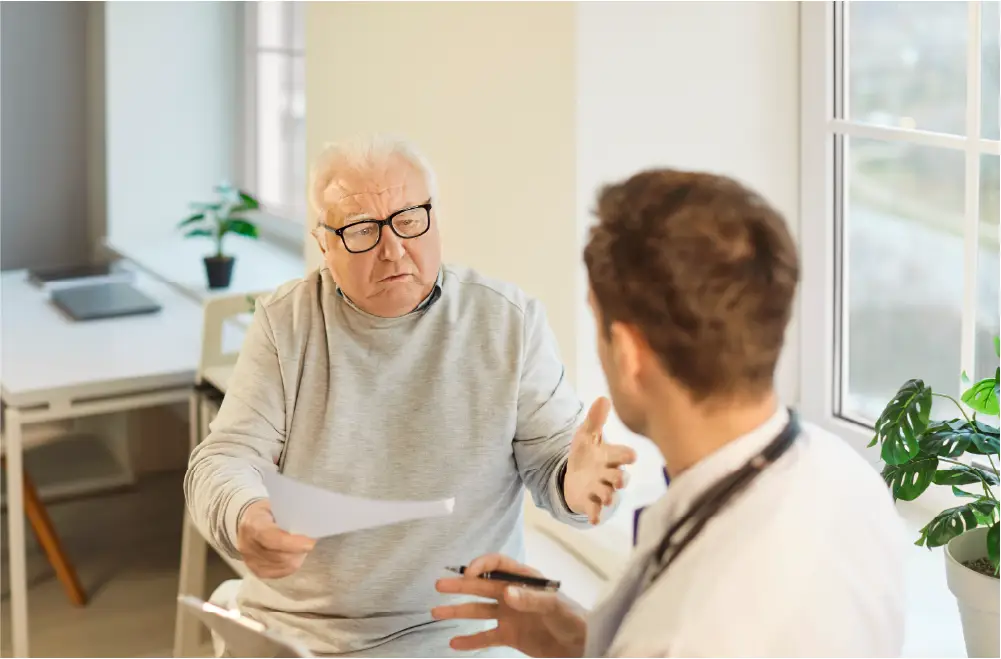 Senior man asking the vein doctor questions prior to receiving treatment