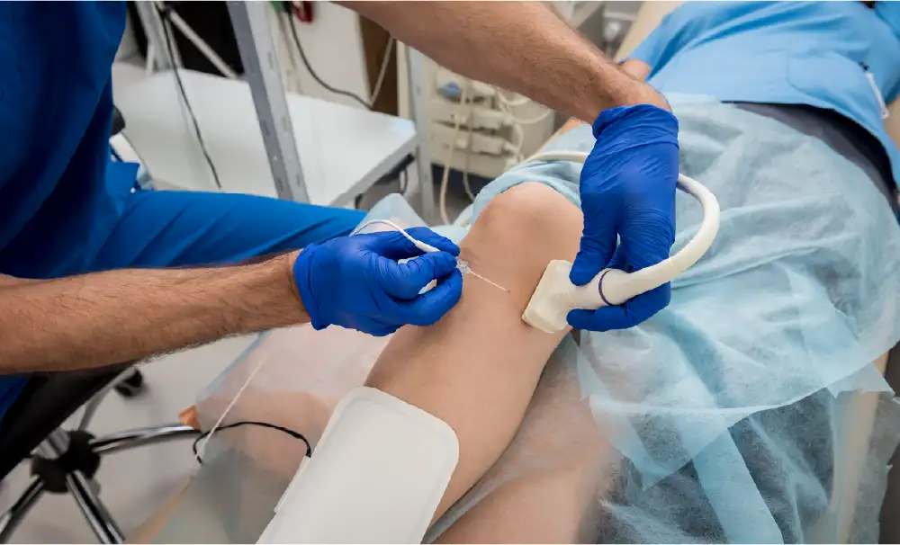 A vein doctor performing ultrasound-guided sclerotherapy on a patient's leg.