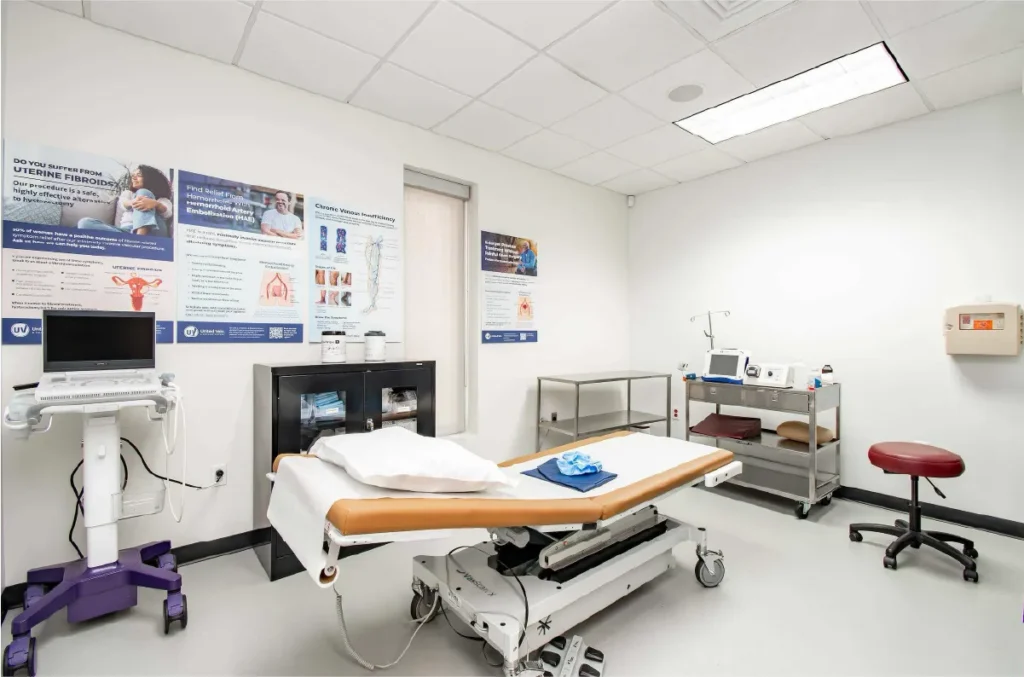 A vein and vascular clinic exam room with a patient table in the middle and various medical equipment against the walls