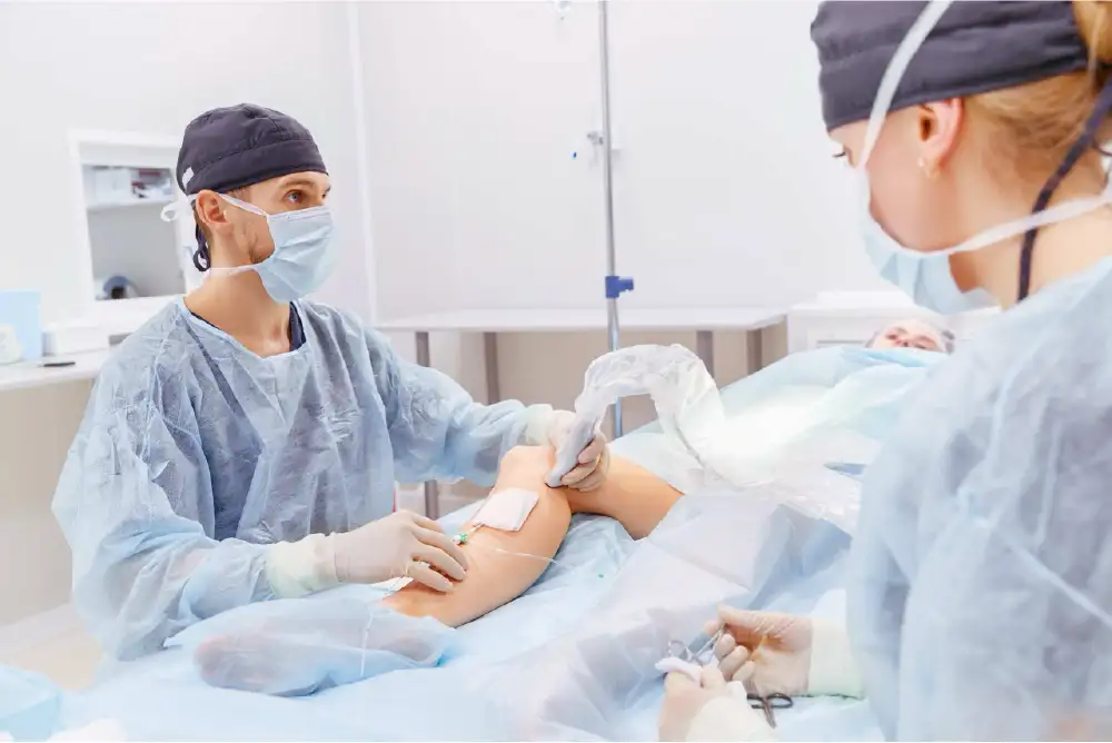 A vein doctor is performing minimally invasive vein treatment on a patient's lower leg